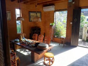 a room with a table and chairs and windows at WuYuan QiYe YanXiang Guesthouse in Wuyuan