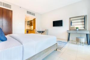 a bedroom with a white bed and a table at Icon Casa Living - Boulevard View in Dubai