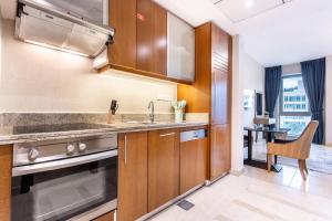 a kitchen with wooden cabinets and a sink at Icon Casa Living - Boulevard View in Dubai