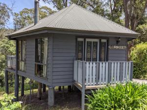 a small grey house with a porch and a roof at Romantic Cabin Escapes Barrington Tops - Lorikeet in Bandon Grove