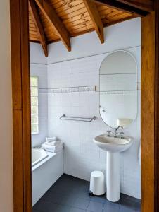 a bathroom with a sink and a mirror and a tub at Romantic Cabin Escapes Barrington Tops - Lorikeet in Bandon Grove