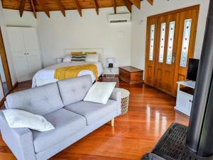 a living room with a couch and a bed at Romantic Cabin Escapes Barrington Tops - Lorikeet in Bandon Grove