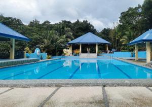 a large blue swimming pool with a gazebo at MJS Campsite and Mountain Resort in Balilihan