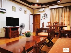 sala de estar con mesa y TV en Sand-D House Pool Villa C18 at Rock Garden Beach Resort Rayong, en Mae Pim