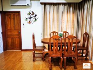 a dining room with a wooden table and chairs at Sand-D House Pool Villa C18 at Rock Garden Beach Resort Rayong in Mae Pim