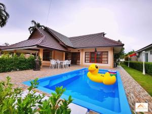 una casa con una piscina con dos patos de goma. en Sand-D House Pool Villa C18 at Rock Garden Beach Resort Rayong, en Mae Pim