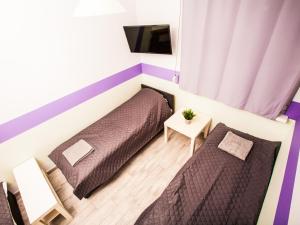 niewielka sypialnia z 2 łóżkami i telewizorem w obiekcie SUDO studios we Wrocławiu