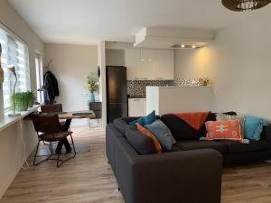 a living room with a couch and a kitchen at Holiday aan de Kust in Rijnsburg