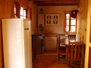 uma cozinha com um frigorífico branco e uma mesa em Hosteria Catalina sm em Hornopirén