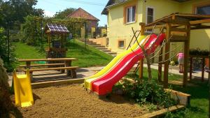 - une aire de jeux avec toboggan coloré dans la cour dans l'établissement Rekreačný dom Railip, à Trávnica