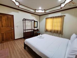 een slaapkamer met een wit bed en een houten vloer bij Sand-D House Pool Villa A8 at Rock Garden Beach Resort Rayong in Ban Ao Makham Pom
