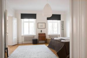 a bedroom with a bed and two windows at Exclusive and light 3 room appartment in SoFo 97sqm in Stockholm