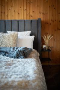 a bed with a gray headboard and white pillows at Chalet Horn in Davos Wolfgang