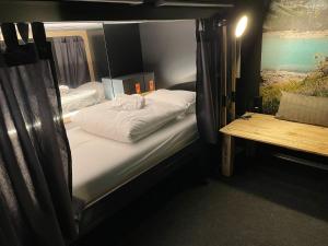 a bedroom with a bed and a lamp at Capsule Hotel - Alpine Garden Zurich Airport in Kloten