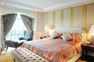 a bedroom with a bed and a chair and a window at Al Meroz Hotel Bangkok - The Leading Halal Hotel in Bangkok
