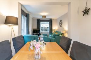 a living room with a wooden table and blue chairs at Two Bedroom Ground Floor Flat in Bridge of Allan