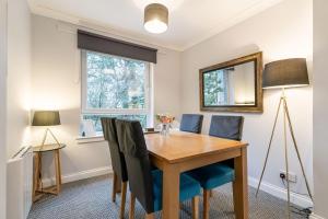 a dining room with a wooden table and chairs at Two Bedroom Ground Floor Flat in Bridge of Allan