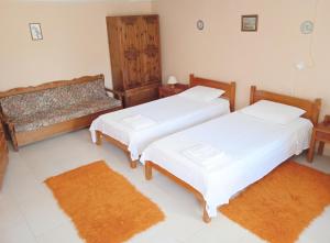 two beds in a room with two rugs at Akis Garden in Anemómylos