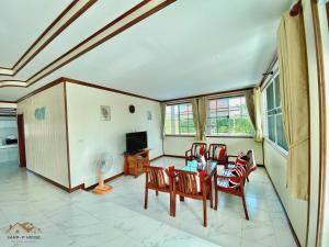 een woonkamer met een tafel en stoelen en een televisie bij Sand-D House Pool Villa A6 at Rock Garden Beach Resort Rayong in Ban Ao Makham Pom