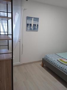 a bedroom with a bed and a picture of boats on the wall at Appartement PLOEMEUR-Fort Bloqué in Ploemeur