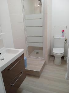 uma casa de banho branca com um WC e um chuveiro em Appartement PLOEMEUR-Fort Bloqué em Ploemeur