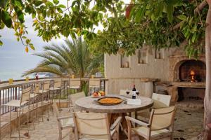 einen Tisch und Stühle am Strand mit Kamin in der Unterkunft Buccara Villa Mistral in Villajoyosa