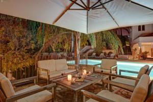uma piscina com cadeiras, uma mesa e um guarda-sol em Buccara Villa Mistral em Villajoyosa