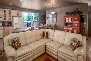 a living room with a white couch and a kitchen at Adobe Hacienda, 3 Bedrooms, Sleeps 8, Gas Grill, Fenced Yard, WiFi in Ruidoso