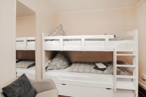 two white bunk beds in a room with a chair at Fewo Clemensberg Niedersfeld in Winterberg