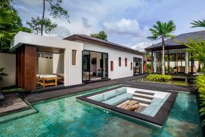 a villa with a swimming pool in front of a house at Villa Lagoon by BaliSuperHost in Ubud