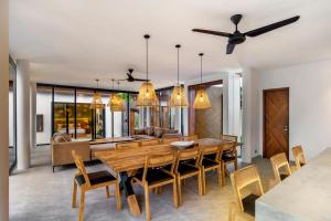 a dining room and living room with a wooden table and chairs at Villa Lagoon by BaliSuperHost in Ubud