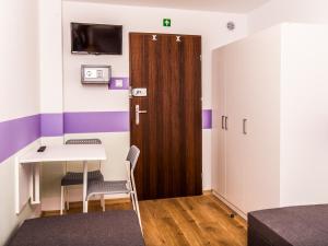 a room with a wooden door and a table and chairs at SUDO rooms in Wrocław