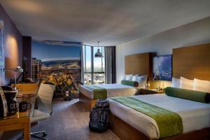 a hotel room with two beds and a desk at Whitney Peak Hotel Reno, Tapestry Collection by Hilton in Reno +37 photos