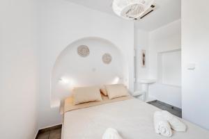 a white bedroom with a bed and two towels at Endless Blue from Syros - Vari Resort in Vári