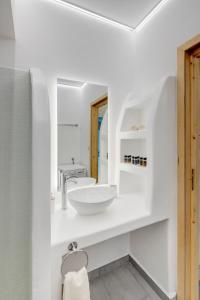 a white bathroom with a sink and a mirror at Endless Blue from Syros - Vari Resort in Vári +55 photos