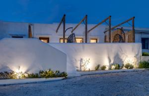 a white wall with lights on it at night at Endless Blue from Syros - Vari Resort in Vári
