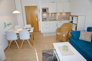 ein Wohnzimmer mit einem blauen Sofa und einem Tisch in der Unterkunft Kajüte 5 in Dahme