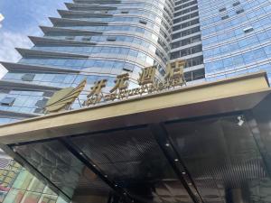 un edificio con un cartello sopra un edificio di New Century Hotel Qianchao Hangzhou a Hangzhou