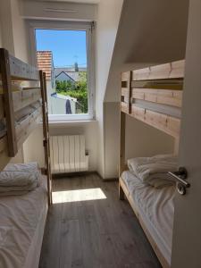 two bunk beds in a room with a window at Maison les figuiers Roch Priol in Quiberon