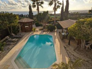 een uitzicht over een zwembad in een tuin bij Villa Pontus - stunning views & privacy in beautiful garden with pool & hot tub in Kouklia