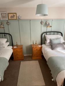 a bedroom with two beds and two night stands at Bell Cottage right in the heart of Bridgnorth in Bridgnorth