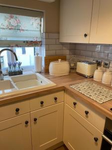 uma cozinha com um lavatório e uma bancada em Bell Cottage right in the heart of Bridgnorth em Bridgnorth