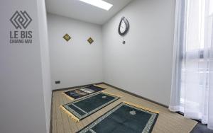 a room with a clock on the wall and a rug at Le Bis Hotel in Chiang Mai +50 photos