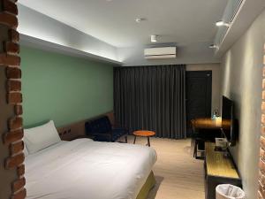 een hotelkamer met een bed en een bureau bij RenShan Homestay in Taitung