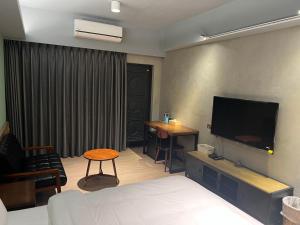 a hotel room with a bed and a flat screen tv at RenShan Homestay in Taitung City