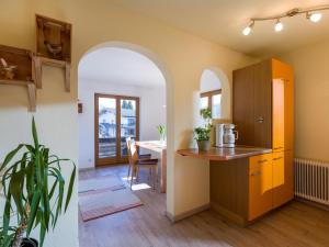 una cucina con arco e una sala da pranzo con tavolo di Apartment Rabl a Kirchbichl