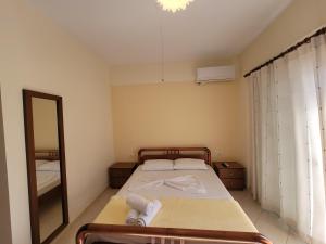 a small bedroom with a bed and a mirror at Mihasi Apartments in Ksamil