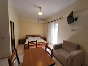 a room with two beds and a table and a couch at Mihasi Apartments in Ksamil