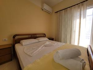 a bedroom with a bed with towels on it at Mihasi Apartments in Ksamil