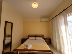 a bedroom with a bed and a mirror and a window at Mihasi Apartments in Ksamil